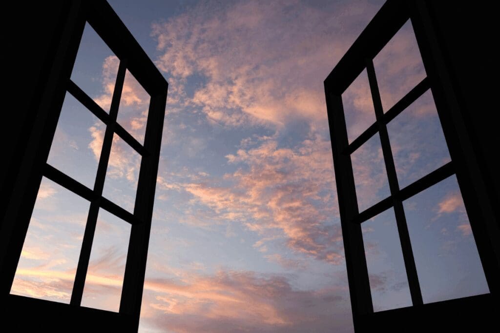 Open window looking out to a soft dawn sky, representing the body's restoration during sleep